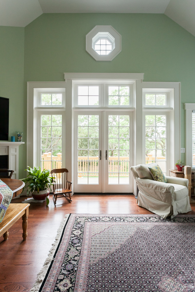 Imagen de salón clásico con paredes verdes y suelo de madera en tonos medios