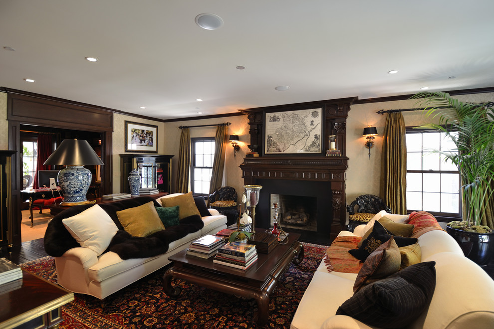 This is an example of a large traditional living room curtain in Los Angeles with beige walls, a standard fireplace, dark hardwood flooring and a wooden fireplace surround.