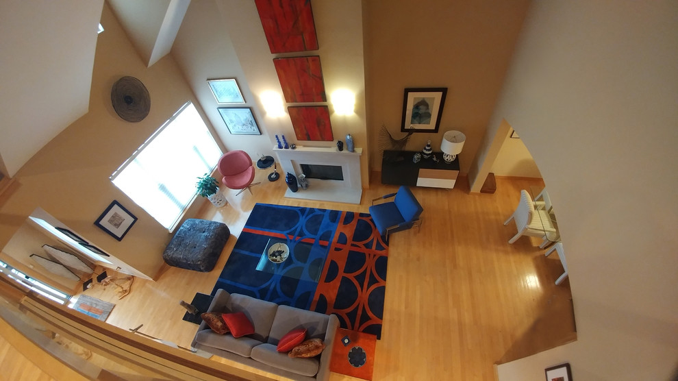 Großes, Fernseherloses Modernes Wohnzimmer im Loft-Stil mit beiger Wandfarbe, hellem Holzboden, Kamin, Kaminumrandung aus Beton und beigem Boden in Detroit