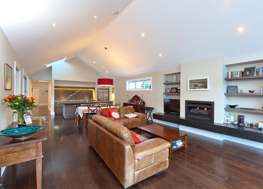 Idee per un soggiorno minimal di medie dimensioni e aperto con pareti beige, pavimento in legno massello medio, camino classico, TV autoportante e pavimento marrone
