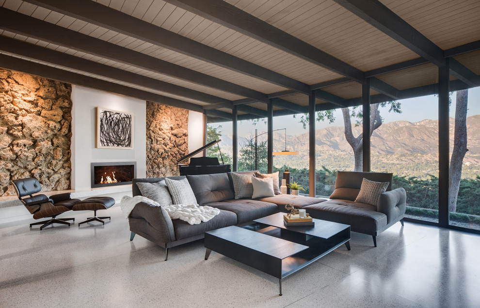 This is an example of a midcentury open plan living room in Los Angeles with a ribbon fireplace, a plastered fireplace surround and white floors.