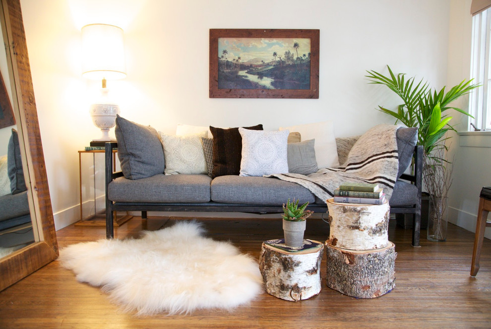 Photo of a medium sized retro enclosed living room in Los Angeles with white walls, medium hardwood flooring, no fireplace and brown floors.