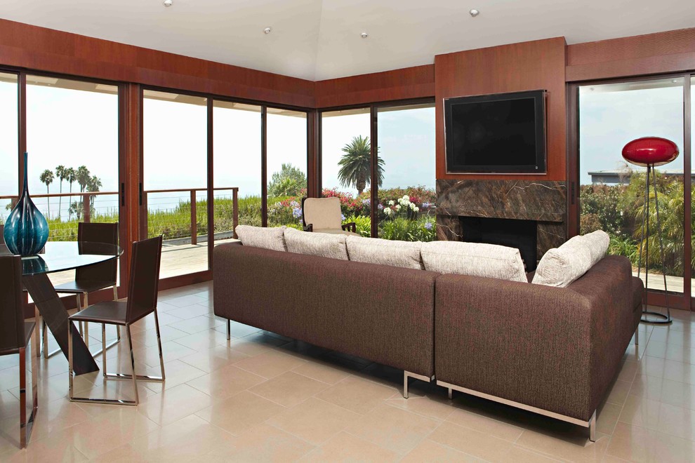 Идея дизайна: большая открытая гостиная комната в стиле модернизм с телевизором на стене, коричневыми стенами, полом из керамогранита, стандартным камином и фасадом камина из камня