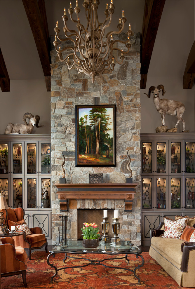 Cette photo montre un salon montagne avec un mur beige, parquet foncé, une cheminée standard et un manteau de cheminée en pierre.