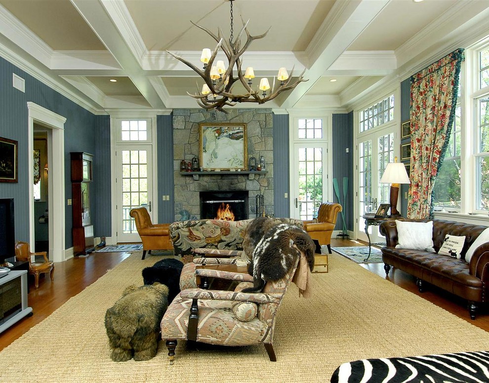Klassisches Wohnzimmer mit blauer Wandfarbe, dunklem Holzboden, Kamin, Kaminumrandung aus Stein und freistehendem TV in New York