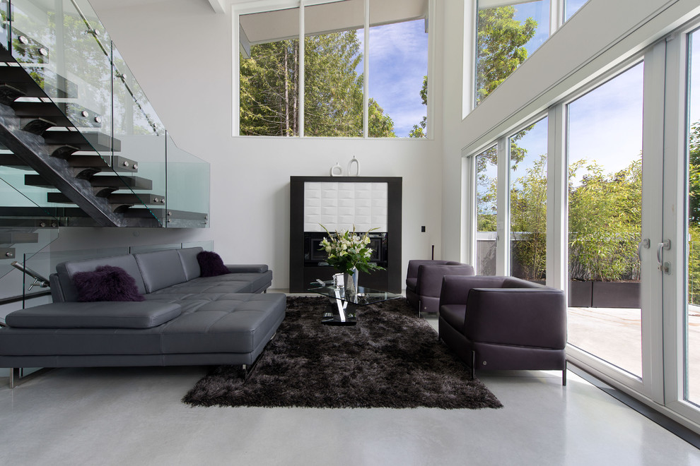 Esempio di un soggiorno minimalista stile loft con pareti bianche, pavimento in cemento, camino classico, cornice del camino piastrellata e nessuna TV
