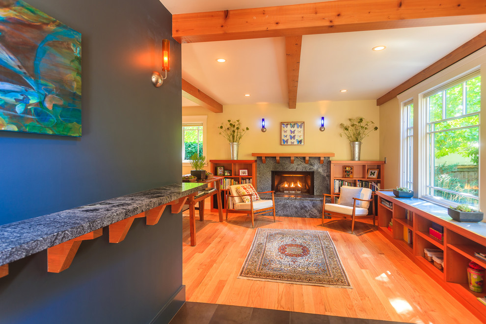 Imagen de salón actual con suelo de madera en tonos medios, todas las chimeneas y marco de chimenea de piedra