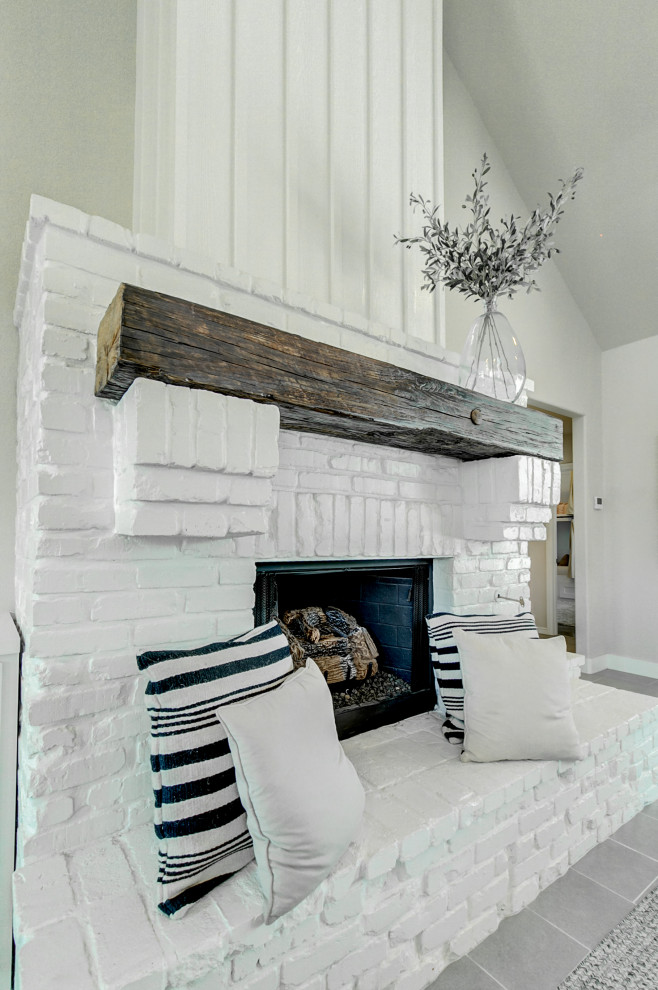 Свежая идея для дизайна: открытая гостиная комната среднего размера в стиле рустика с серыми стенами, полом из керамической плитки, стандартным камином, фасадом камина из кирпича и серым полом - отличное фото интерьера