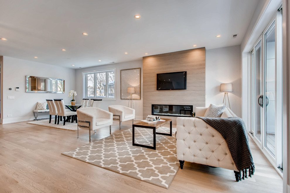 Example of a trendy open concept light wood floor and beige floor living room design in Chicago with white walls, a ribbon fireplace and a wall-mounted tv