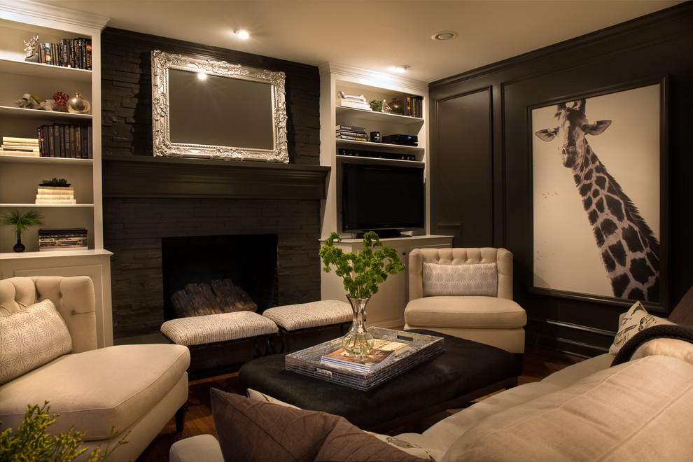 Small classic formal enclosed living room in Charlotte with black walls, medium hardwood flooring, a standard fireplace, a stone fireplace surround, a built-in media unit and brown floors.