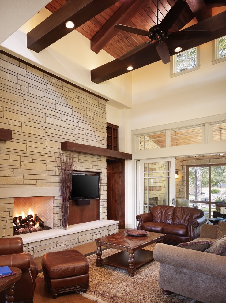 Imagen de salón de estilo americano con marco de chimenea de piedra, piedra y alfombra