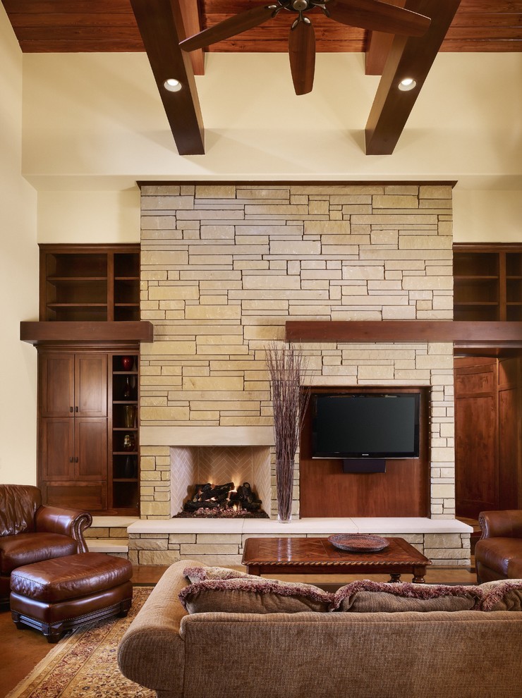Traditional living room in Austin with a stone fireplace surround.