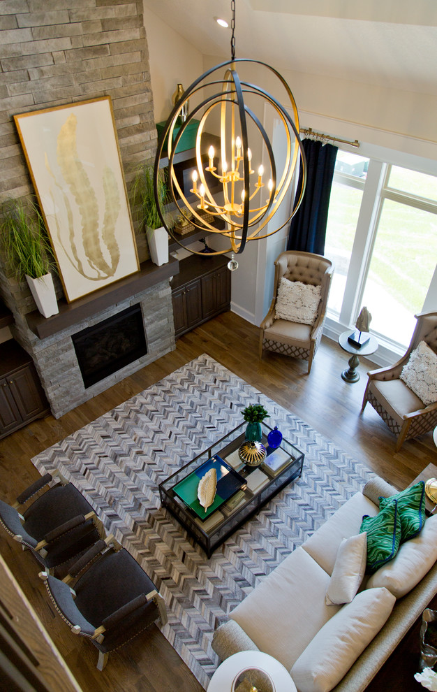 Großes, Repräsentatives, Offenes Modernes Wohnzimmer mit beiger Wandfarbe, braunem Holzboden, Kamin, Kaminumrandung aus Stein und braunem Boden in Kansas City
