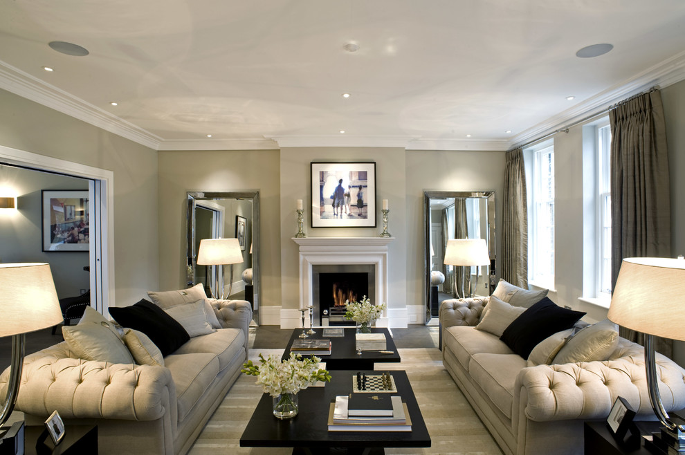 Пример оригинального дизайна: изолированная гостиная комната в стиле неоклассика (современная классика) с бежевыми стенами, стандартным камином и красивыми шторами