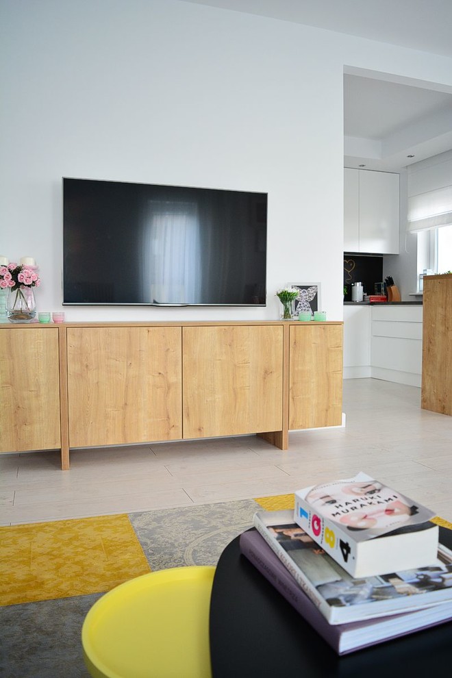Источник вдохновения для домашнего уюта: открытая гостиная комната среднего размера в скандинавском стиле с белыми стенами, светлым паркетным полом и телевизором на стене без камина