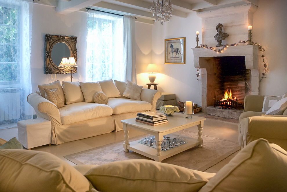 Réalisation d'un grand salon champêtre fermé avec un mur blanc, parquet clair, une cheminée standard, un manteau de cheminée en pierre et un sol beige.