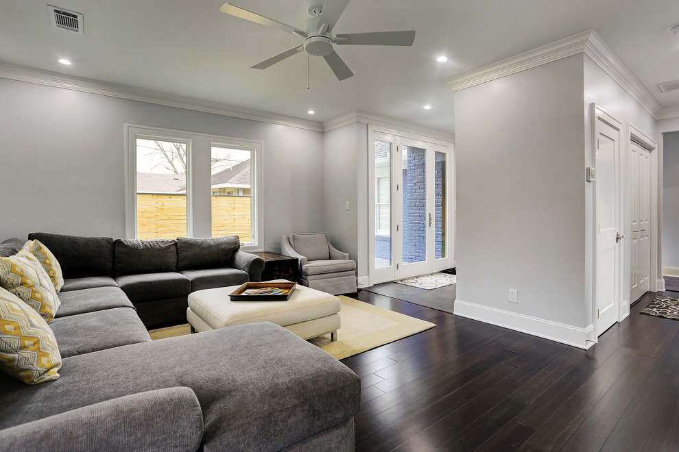 Mittelgroßes, Abgetrenntes Klassisches Wohnzimmer mit grauer Wandfarbe, dunklem Holzboden, TV-Wand und braunem Boden in Houston