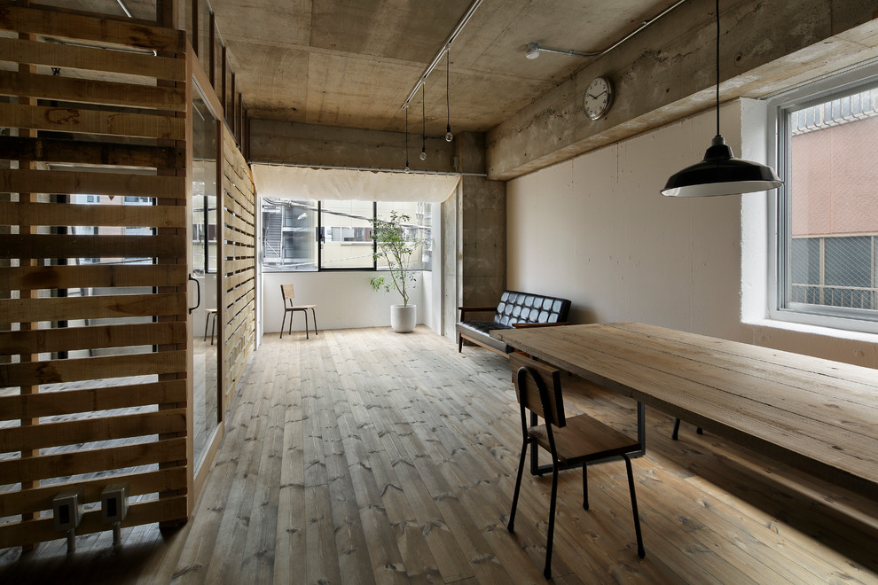 Fernseherloses Industrial Wohnzimmer ohne Kamin mit braunem Holzboden und braunem Boden in Tokio