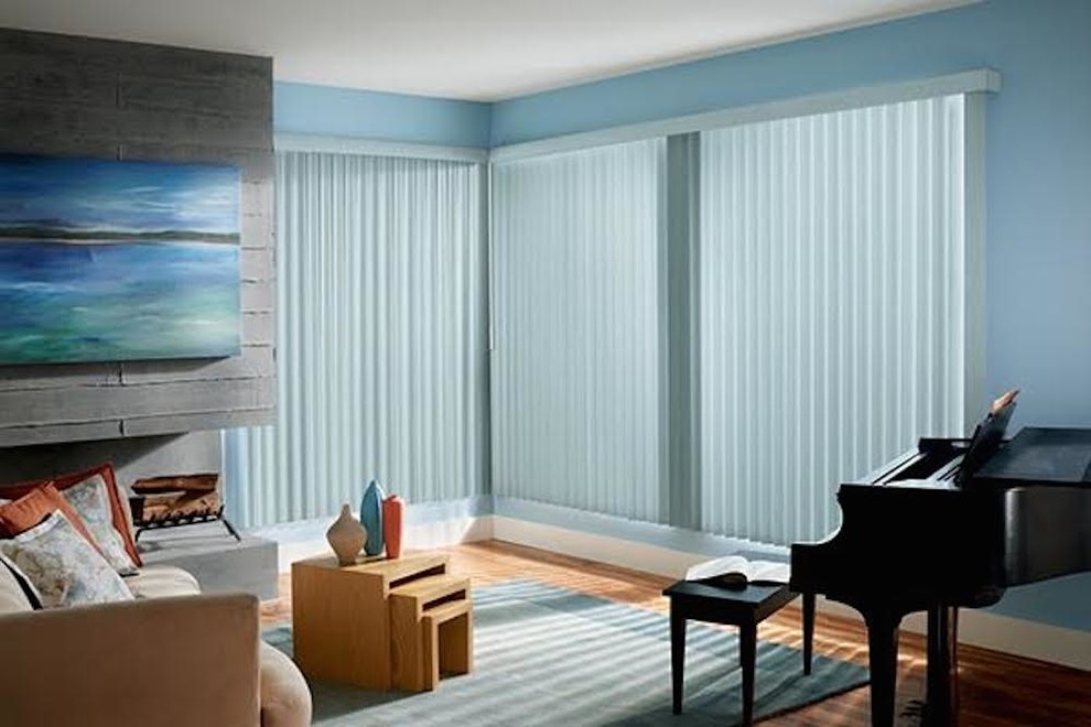 Cette image montre un salon minimaliste de taille moyenne et fermé avec une salle de musique, un mur bleu, un sol en bois brun, une cheminée ribbon, un manteau de cheminée en pierre, aucun téléviseur et un sol marron.