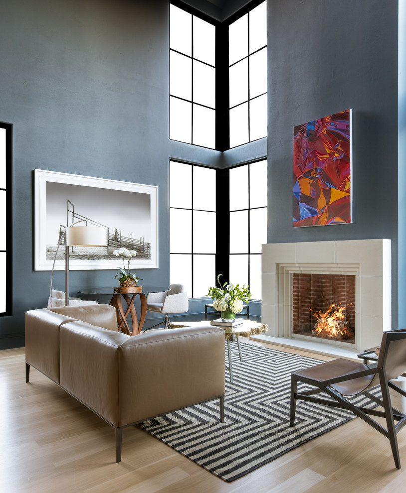 Offenes Modernes Wohnzimmer mit blauer Wandfarbe, hellem Holzboden, Kamin und beigem Boden in Dallas