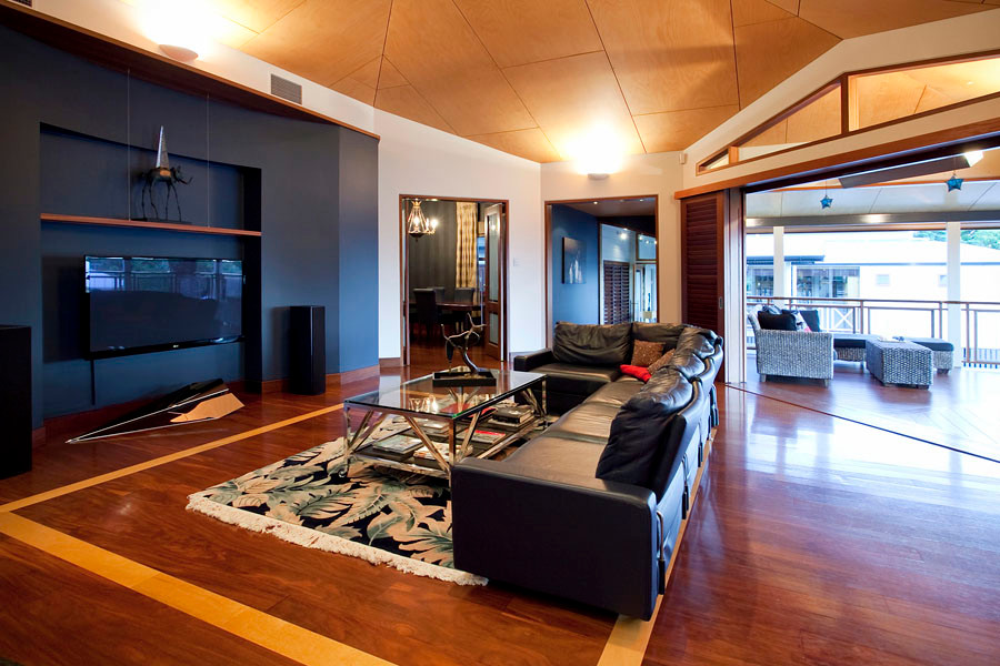 Photo of an expansive traditional open plan living room in Brisbane with multi-coloured walls, medium hardwood flooring, a wall mounted tv and brown floors.