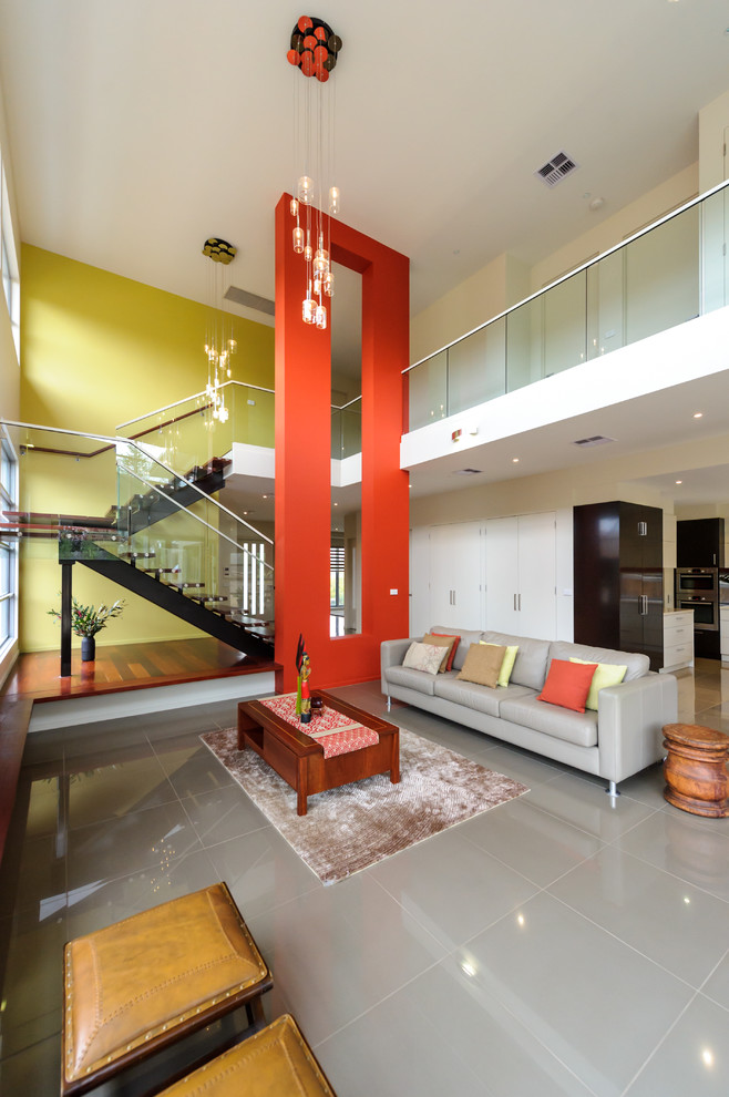 Esempio di un grande soggiorno contemporaneo aperto con pareti gialle, pavimento in gres porcellanato, pavimento grigio e tappeto