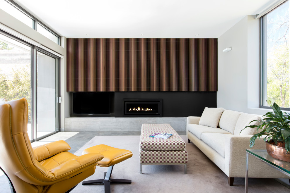Идея дизайна: открытая гостиная комната среднего размера в стиле модернизм с серыми стенами, бетонным полом, стандартным камином, фасадом камина из металла, скрытым телевизором, серым полом и деревянными стенами