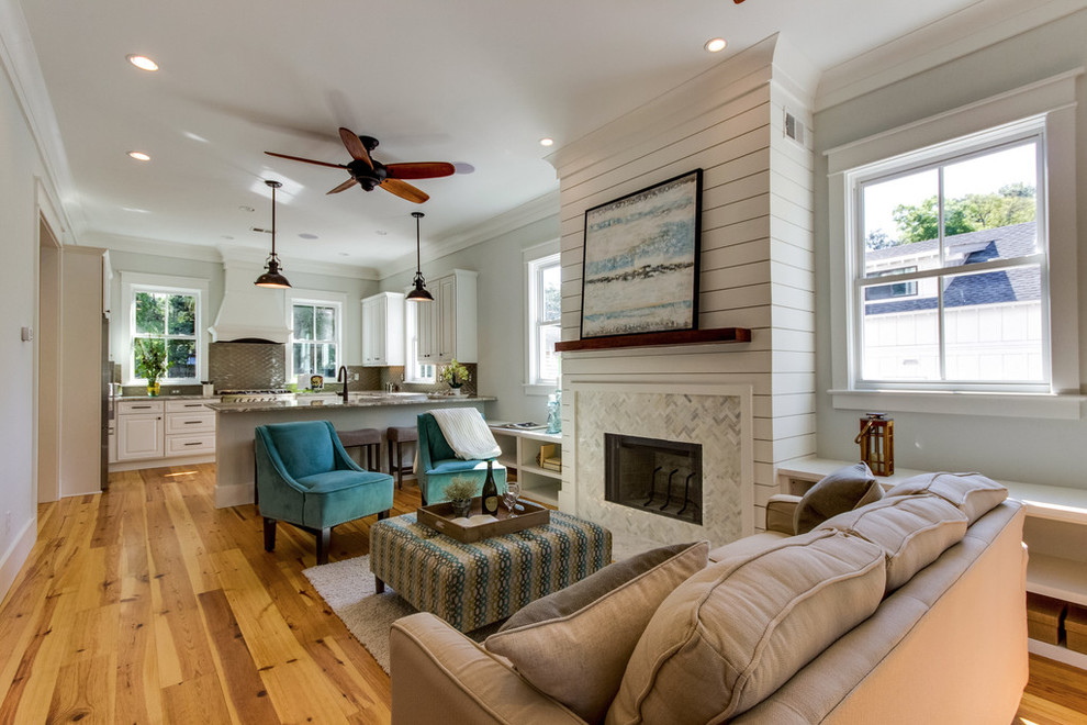 Offenes, Repräsentatives Maritimes Wohnzimmer mit hellem Holzboden, grauer Wandfarbe, Kamin und gefliester Kaminumrandung in Charleston