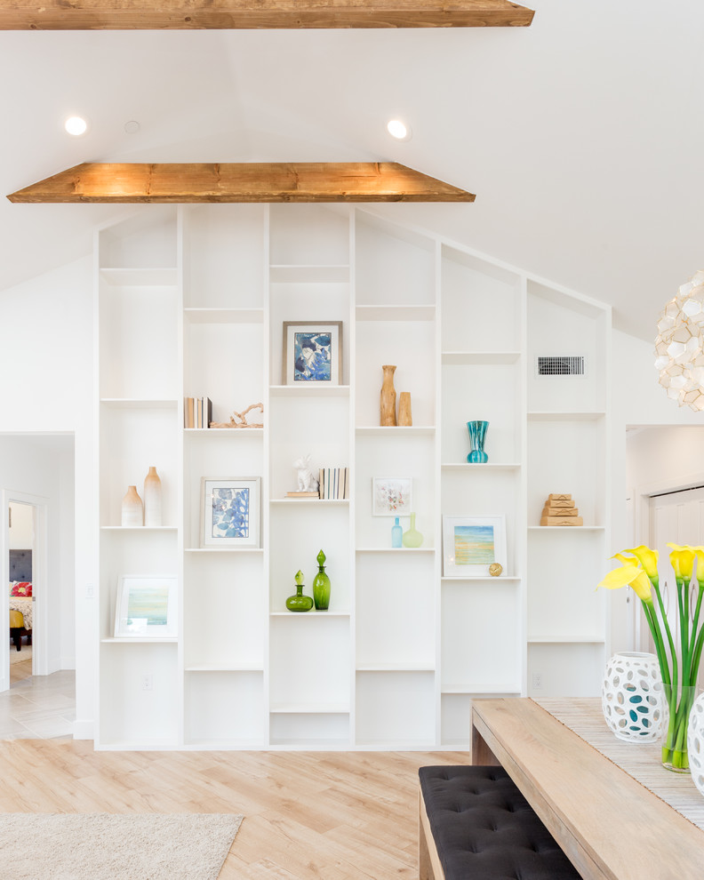 Diseño de salón abierto actual de tamaño medio con paredes blancas, suelo de madera clara y televisor colgado en la pared