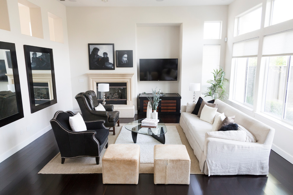 На фото: гостиная комната в стиле неоклассика (современная классика) с белыми стенами, темным паркетным полом, угловым камином, телевизором на стене и черным полом