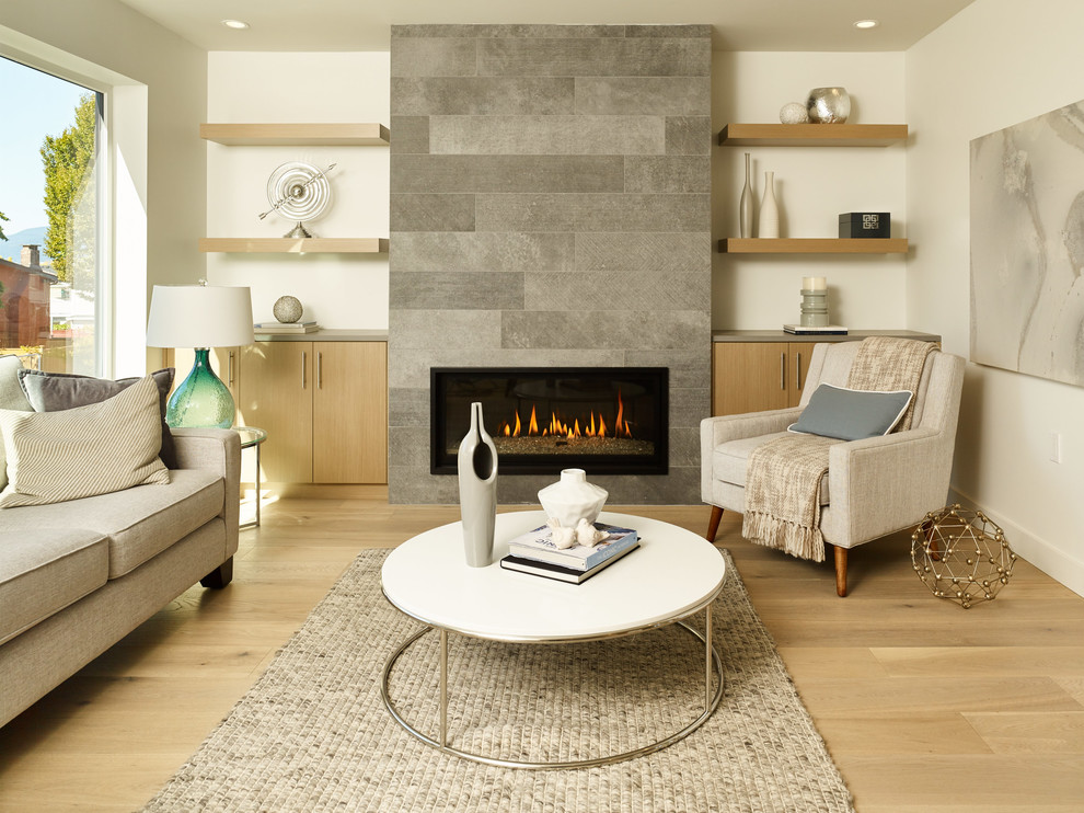 Diseño de salón actual de tamaño medio sin televisor con paredes blancas, suelo de madera clara, marco de chimenea de piedra, chimenea lineal y alfombra