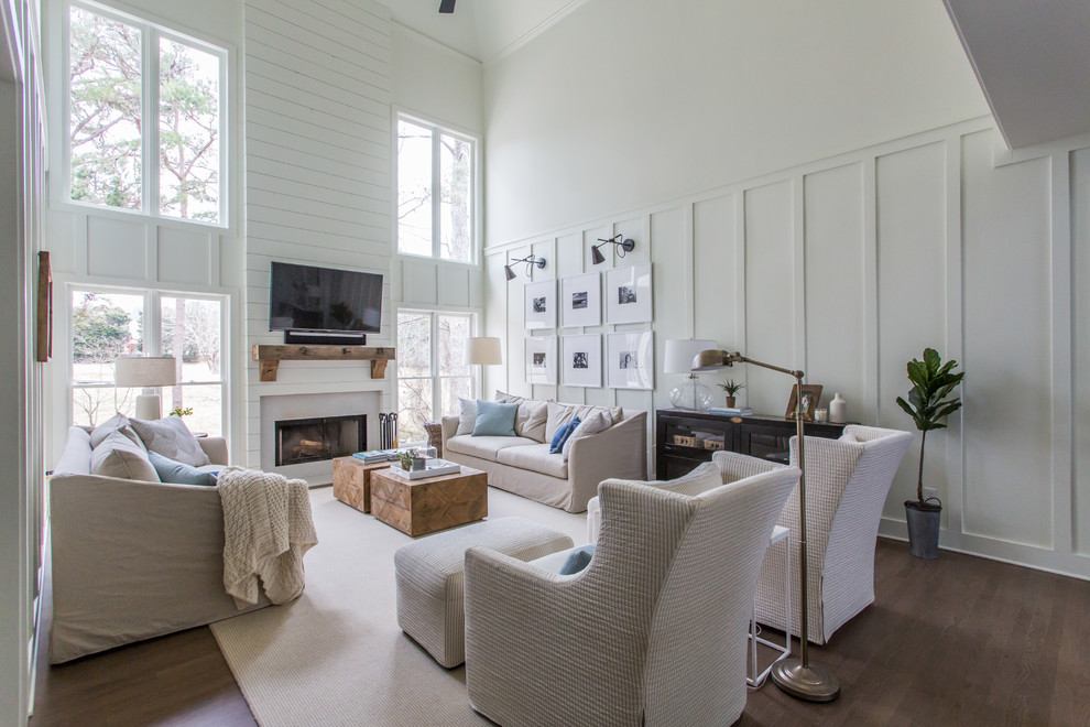 Landhaus Wohnzimmer mit weißer Wandfarbe, braunem Holzboden, Kamin, TV-Wand und braunem Boden in Atlanta