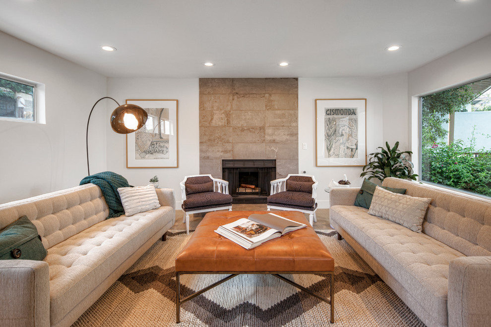 Example of a mid-sized trendy formal medium tone wood floor living room design in Los Angeles with white walls, a standard fireplace and a stone fireplace