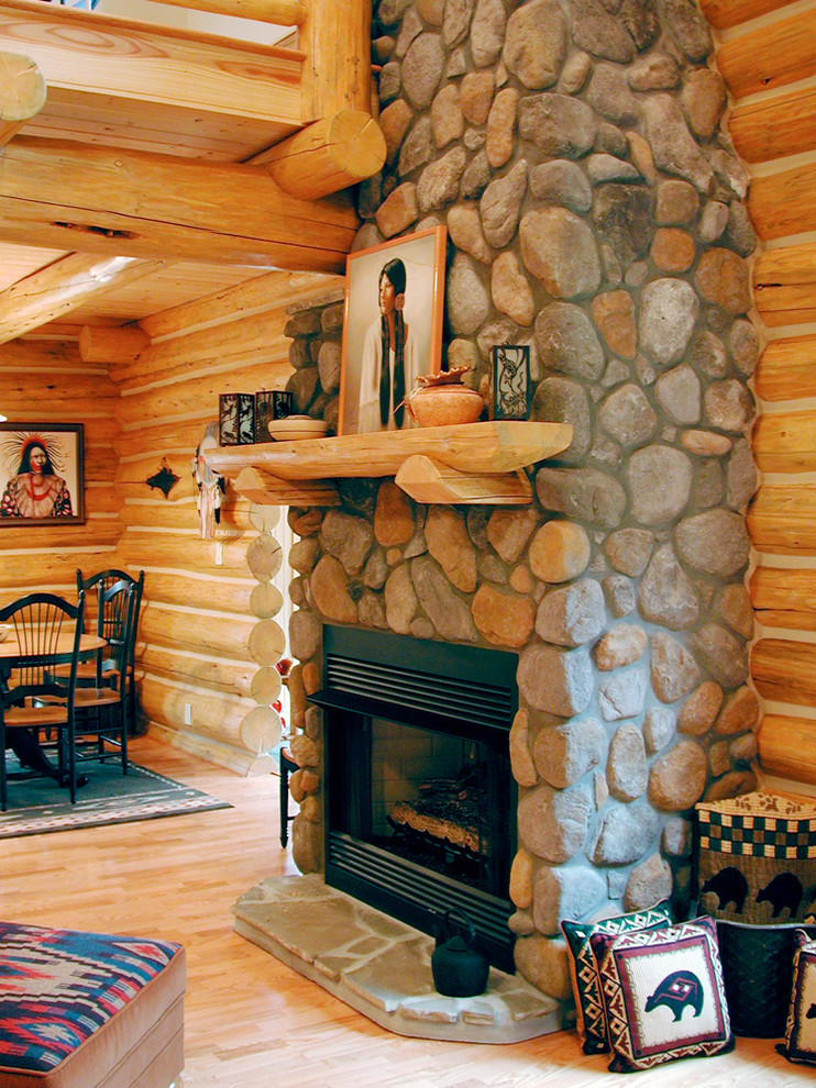Foto de salón tipo loft de estilo americano pequeño con suelo de madera en tonos medios, todas las chimeneas y marco de chimenea de piedra