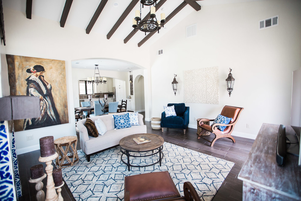 Inspiration for a medium sized mediterranean formal open plan living room in Other with beige walls, dark hardwood flooring, a standard fireplace, a tiled fireplace surround, a freestanding tv and brown floors.