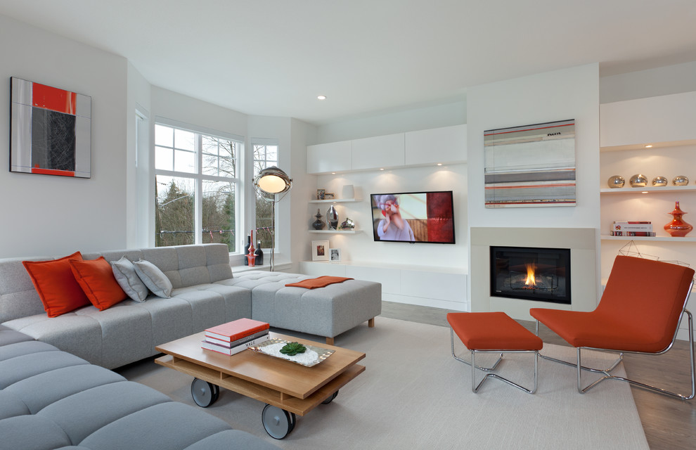 На фото: гостиная комната в современном стиле с стандартным камином, телевизором на стене и эркером