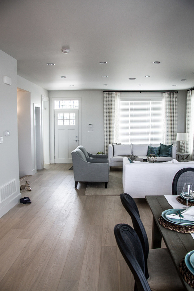 Offenes Klassisches Wohnzimmer mit weißer Wandfarbe, hellem Holzboden, Kamin und Kaminumrandung aus Stein in Vancouver