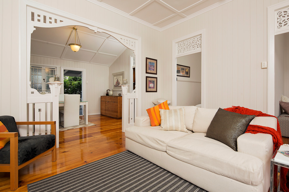 Diseño de salón abierto tradicional renovado pequeño con paredes beige y suelo de madera en tonos medios