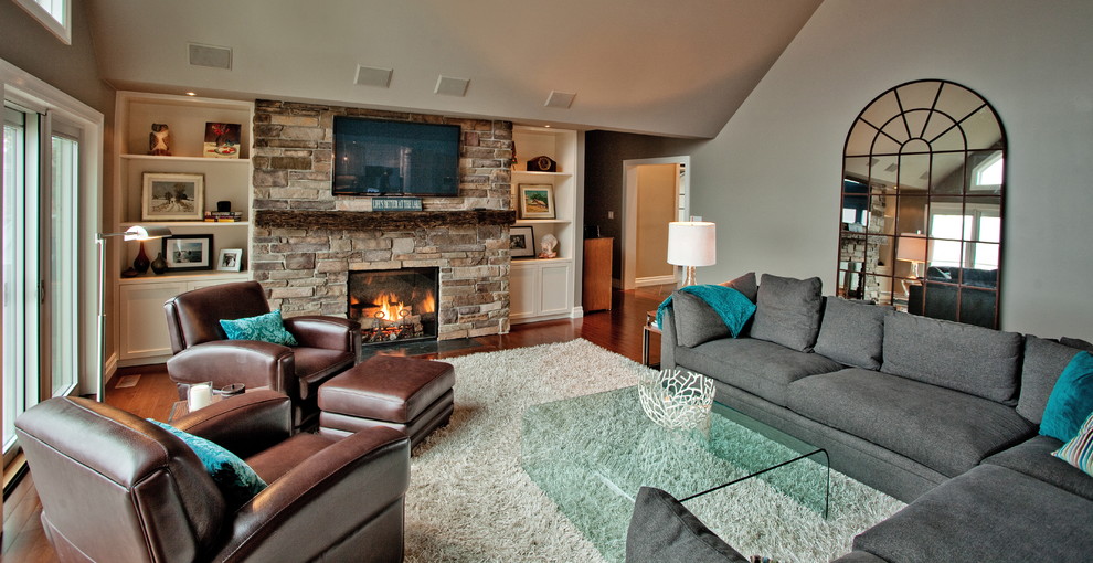 Stilmix Wohnzimmer mit Kaminumrandung aus Stein, TV-Wand, grauer Wandfarbe, dunklem Holzboden und Kamin in Toronto
