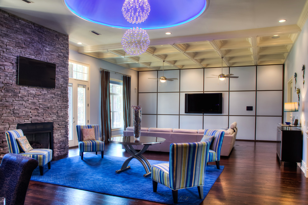 Aménagement d'un salon moderne ouvert avec une salle de réception, un téléviseur fixé au mur, un mur bleu, parquet foncé, une cheminée standard et un manteau de cheminée en pierre.
