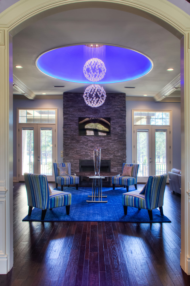 Foto di un soggiorno contemporaneo aperto con sala formale, TV a parete, pareti blu, parquet scuro, camino classico e cornice del camino in pietra