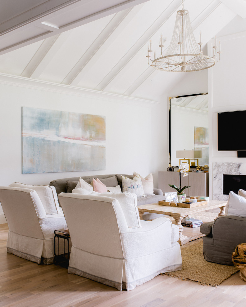 Abgetrenntes Klassisches Wohnzimmer mit weißer Wandfarbe, hellem Holzboden, Kamin, Kaminumrandung aus Stein und TV-Wand in Dallas