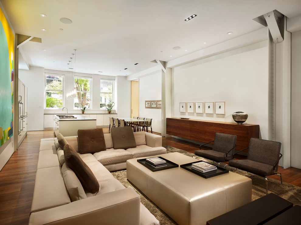 This is an example of a modern open plan living room in San Francisco with white walls and medium hardwood flooring.