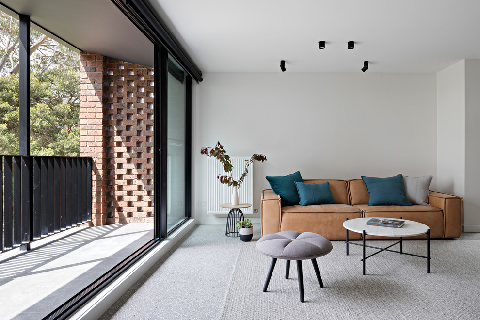 Пример оригинального дизайна: открытая гостиная комната среднего размера в современном стиле с бетонным полом, серыми стенами и коричневым диваном