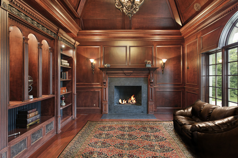 ボルチモアにある中くらいなトラディショナルスタイルのおしゃれなリビング (茶色い壁、濃色無垢フローリング、標準型暖炉、コンクリートの暖炉まわり、テレビなし、茶色い床、ペルシャ絨毯) の写真