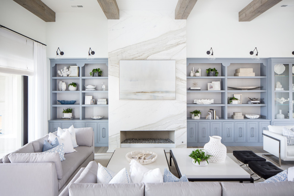 Mediterranes Wohnzimmer mit weißer Wandfarbe, hellem Holzboden, Gaskamin und Kaminumrandung aus Stein in San Diego