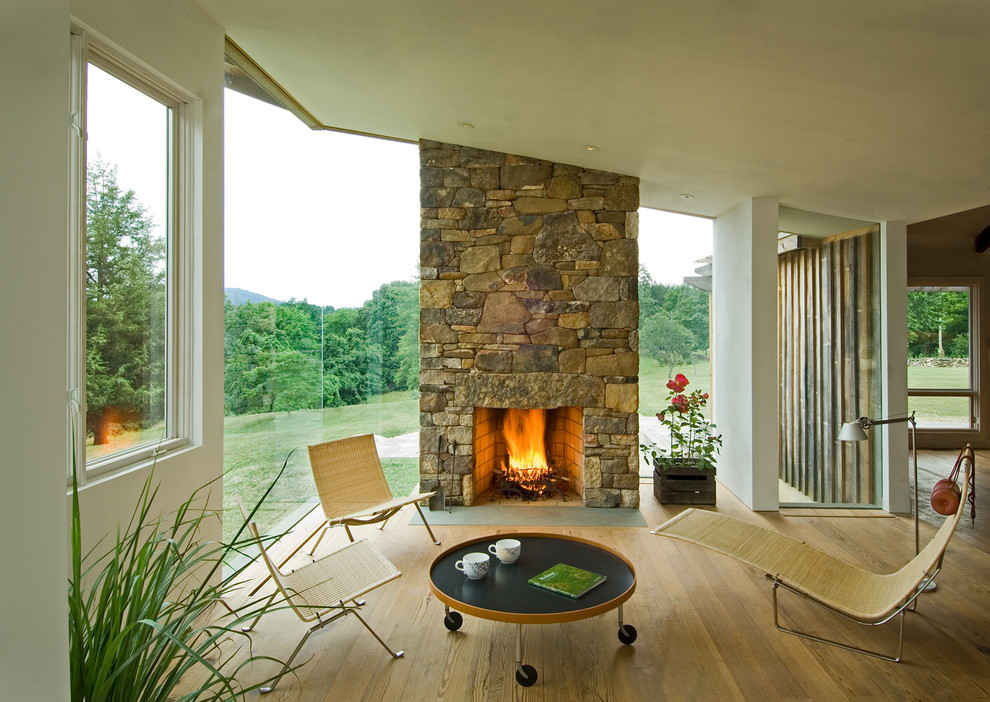 Inspiration pour un salon design avec une cheminée standard et un manteau de cheminée en pierre.