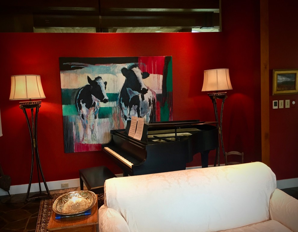 Cette image montre un grand salon bohème ouvert avec un mur rouge, un sol en ardoise, une cheminée double-face, un manteau de cheminée en béton, aucun téléviseur et un sol gris.