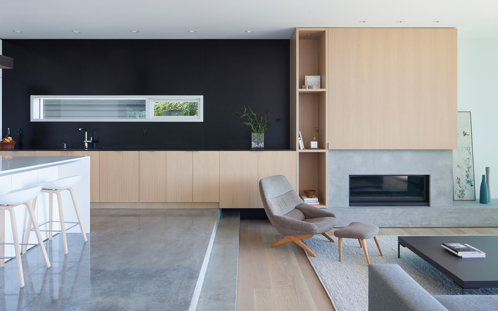 Repräsentatives, Offenes Modernes Wohnzimmer mit schwarzer Wandfarbe, Betonboden, Gaskamin und Kaminumrandung aus Beton in Vancouver