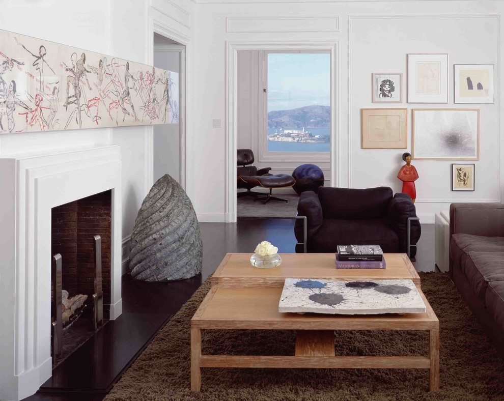 This is an example of a contemporary enclosed living room in San Francisco with white walls and a standard fireplace.